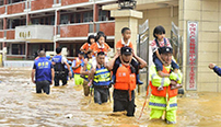 洪水围困乡村小学 学童骑在救援人员肩上撤离